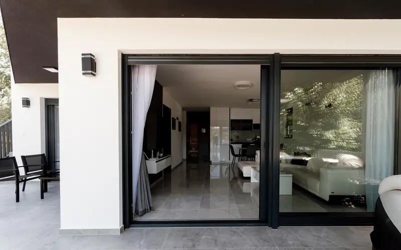 Clear sliding glass doors opening from a patio into a bright living room